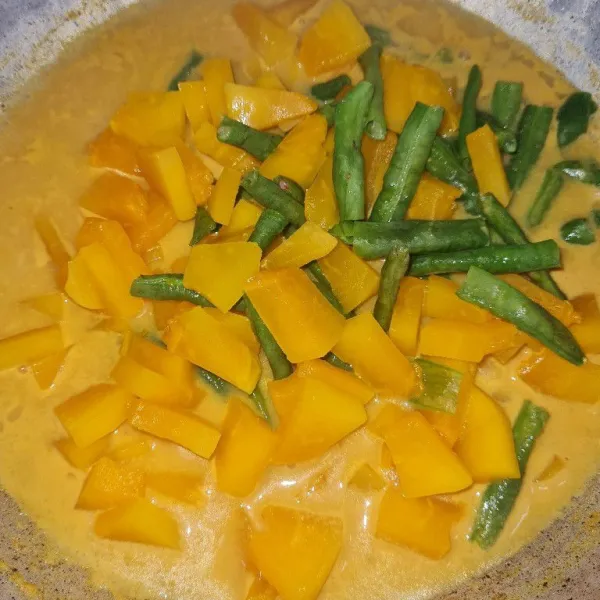 Masukkan pepaya dan kacang panjang, lalu bumbui dengan garam, gula pasir, dan kaldu bubuk. Masak hingga matang.