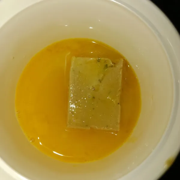 Pecahkan 1 butir telur, lalu masukkan garam dan kaldu bubuk. Aduk rata. masukkan nugget dam balur hingga rata.