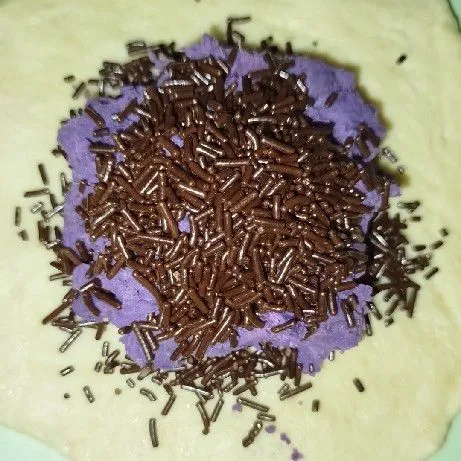 Masukan isian ubi ungu dan juga cokelat meses ke dalam kulit yang telah digilas tadi.