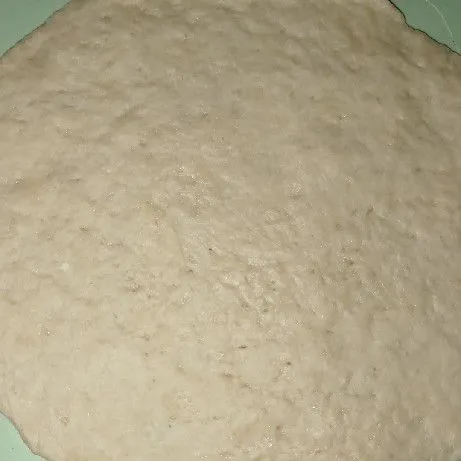 Gilas adonan dengan alat gilas.