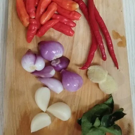 Haluskan cabe rawit, cabe keriting, bawang merah, bawang putih, jahe, dan daun jeruk sebagai bumbu halus.