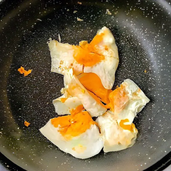 Panaskan minyak goreng di wajan anti lengket, tuang telur dan goreng hingga kedua sisinya matang. Angkat, potong-potong kasar, dan sisihkan