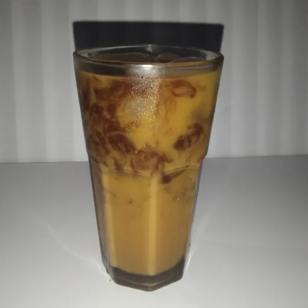 Masukkan es batu, milk tea, jelly, dan tambahan susu full cream beserta dengan gula pasir ke dalam gelas saji.