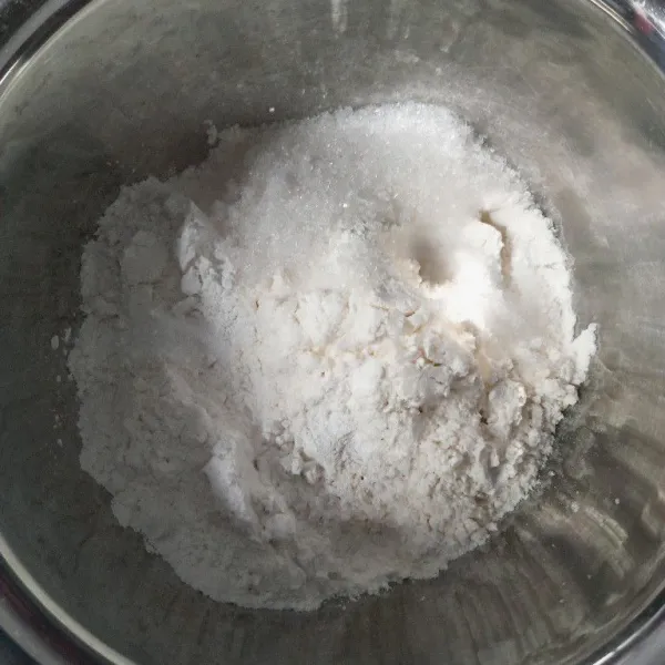 Campurkan tepung terigu, tepung beras, garam, gula pasir, dan baking powder ke dalam wadah.