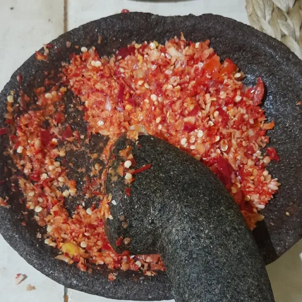 Haluskan tomat, jahe, lengkuas, cabe merah besar, bawang merah, bawang putih, dan kemiri menggunakan ulekan.