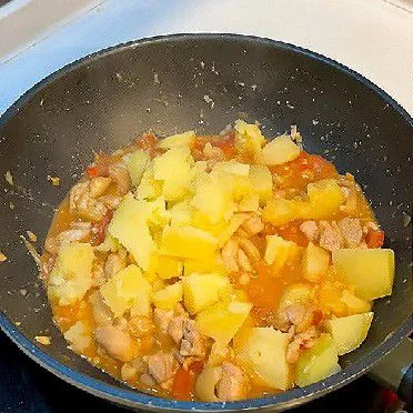 Tambahkan kentang kukus, lalu aduk rata agar tercampur dengan ayam dan saus.