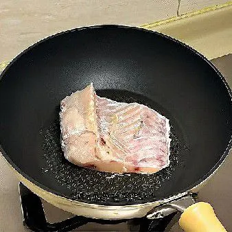 Panaskan minyak goreng di wajan, lalu goreng ikan dengan sisi kulit di bawah terlebih dahulu hingga agak kecokelatan, lalu balik dan masak sisi satunya.
