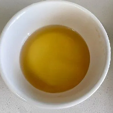 Dalam mangkuk tahan panas, tuangkan air hangat, lalu tambahkan kecap asin. Aduk rata.