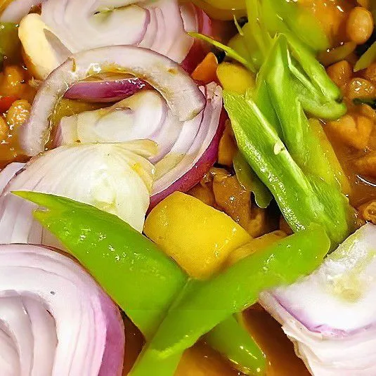 Tambahkan bawang bombay ungu dan paprika hijau, lalu aduk cepat hingga sedikit layu.