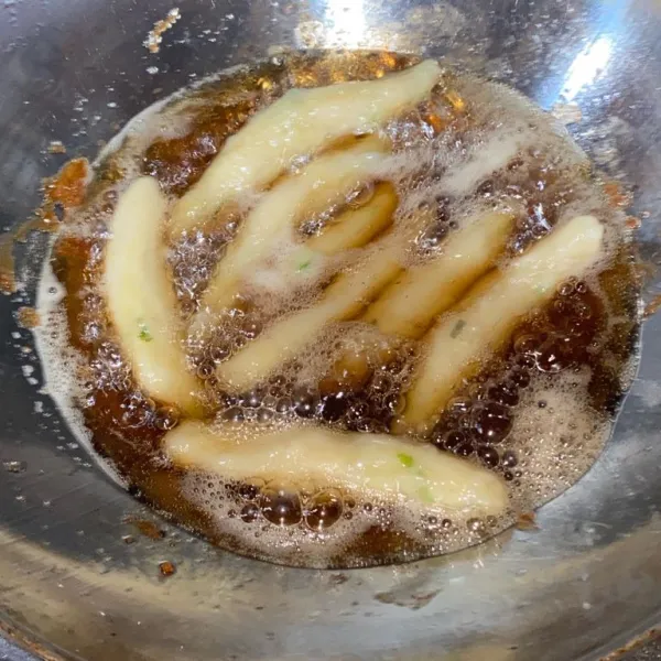 Goreng otak-otak yang sudah matang sampai berubah warna menjadi sedikit kecokelatan.