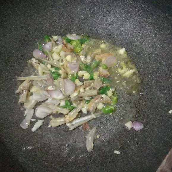 Tumis bumbu dan ikan teri hingga harum.