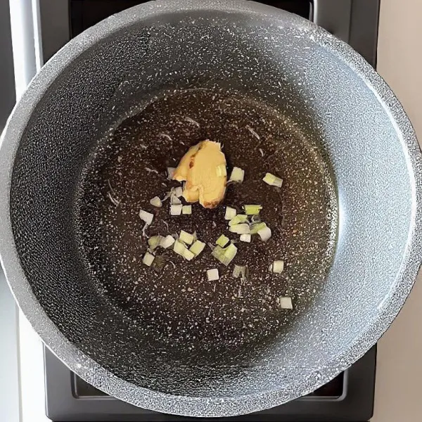 Panaskan minyak sayur dalam panci, lalu masukkan jahe iris dan daun bawang cincang. Tumis hingga harum.