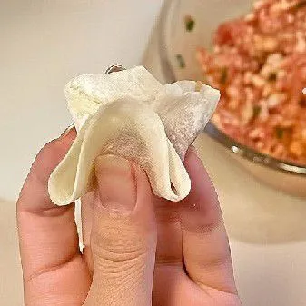 Lipat kulit menjadi bentuk segitiga, kemudian satukan kedua ujung bawahnya ke tengah dan tekan agar menempel rapat.