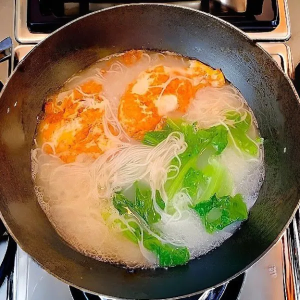 Tambahkan sawi hijau sebelum diangkat, masak hingga layu.