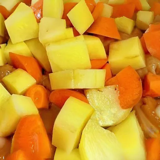 Masukkan kentang dan wortel, lalu aduk rata hingga sedikit layu.