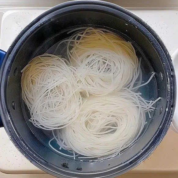 Rendam mie beras dalam air panas selama 10 menit hingga lembut, lalu tiriskan.