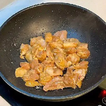 Panaskan minyak goreng dalam wajan, lalu masukkan ayam yang telah dimarinasi dan tumis hingga berubah warna.