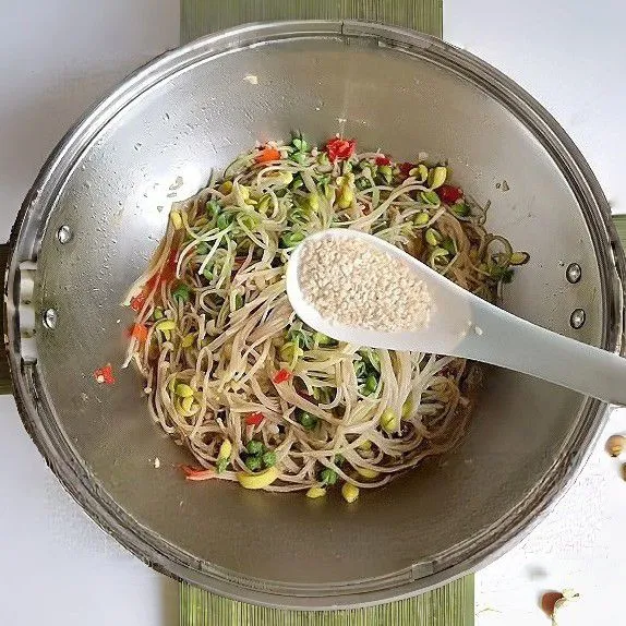 Tuangkan sedikit air, lalu tutup panci dan masak dengan api sedang selama 5 menit hingga sayuran sedikit layu namun tetap renyah. Taburkan wijen sangrai. Aduk rata.