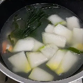 Tuangkan air ke dalam panci, lalu masukkan rumput laut dan potongan labu siam. Rebus dengan api sedang selama ±15 menit hingga labu menjadi bening dan empuk.