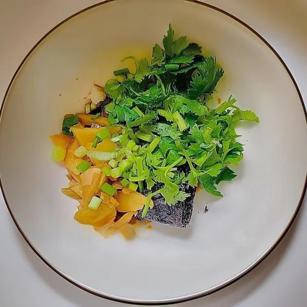 Tambahkan lobak asin cincang, rumput laut kering, daun bawang, dan daun ketumbar.