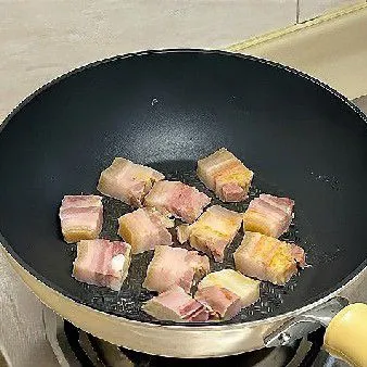 Panaskan minyak di wajan, masukkan potongan perut babi dan tumis hingga berubah warna serta sedikit kecokelatan