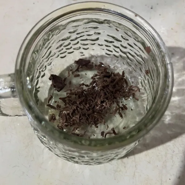 Siapkan gelas saji, lalu beri parutan coklat batang