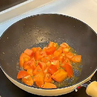 Panaskan minyak goreng di wajan, masukkan 300 gr tomat potong dadu. Tumis hingga tomat mengeluarkan air dan menjadi lembut