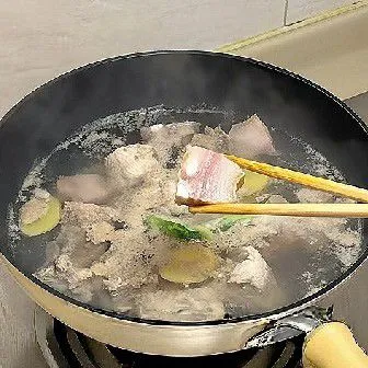 Setelah muncul busa di permukaan, angkat dan buang kotoran, tiriskan daging dan tulang, lalu biarkan hingga kering dari air