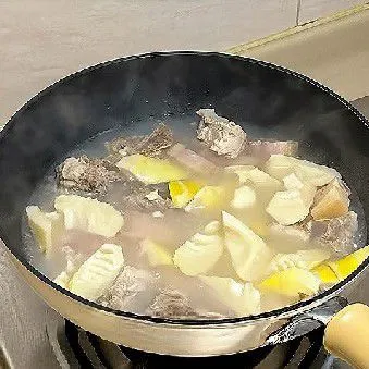 Tambahkan rebung rebus 300 gr ke dalam panci, aduk rata, dan lanjutkan merebus selama sekitar 10 menit hingga daging dan rebung empuk serta kuah meresap
