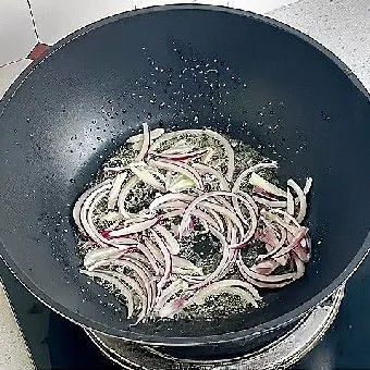 Tumis bawang bombay dengan minyak goreng hingga harum dan layu