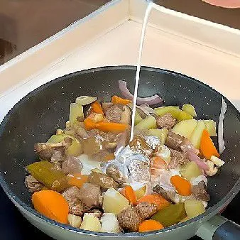 Tambahkan 80 gr pasta kari instan dan tuang 150 ml santan kental, aduk hingga semua bahan terlapisi rata oleh bumbu