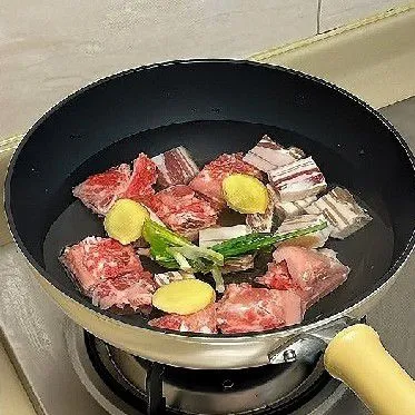 Masukkan perut babi dan tulang iga ke dalam panci, tambahkan 1 liter air, 20 gr jahe, daun bawang 30 gr, dan 15 ml arak masak. Rebus hingga mendidih