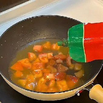 Tambahkan 200 ml air dan 15 ml saus tomat ke dalam tumisan, aduk rata hingga tercampur