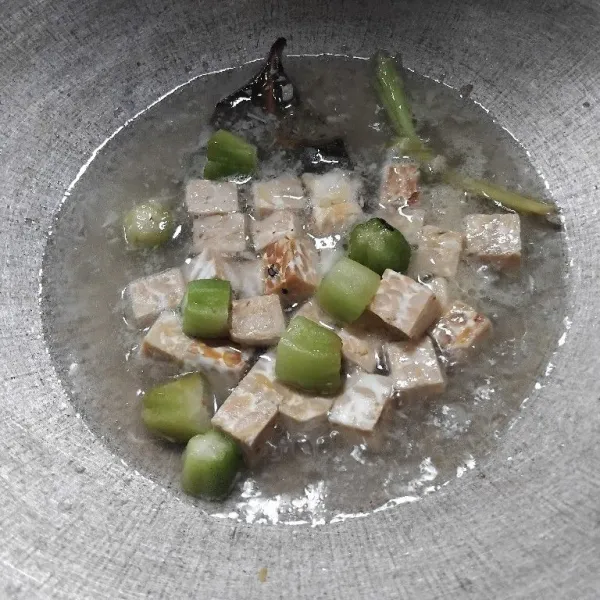Tuangkan air, lalu masukkan tempe dan belimbing wuluh.