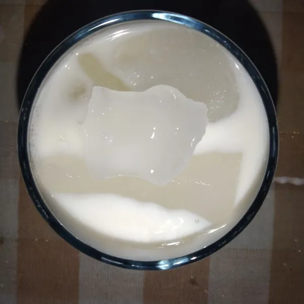 Masukkan es batu dan susu full cream, lalu aduk hingga tercampur rata.