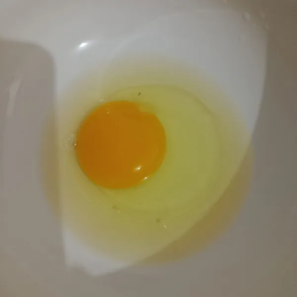 Pecahkan 1 butir telur ke dalam mangkuk.