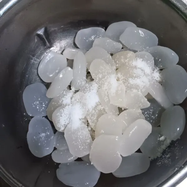 Siram kolang-kaling dengan air mengalir, lalu remas-remas dengan garam. Bilas 2-3 kali.