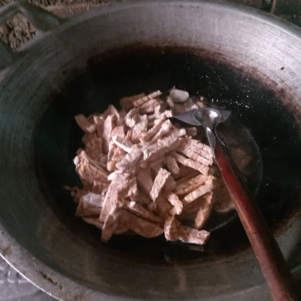 Masukkan air dan tempe, lalu tambahkan gula merah.