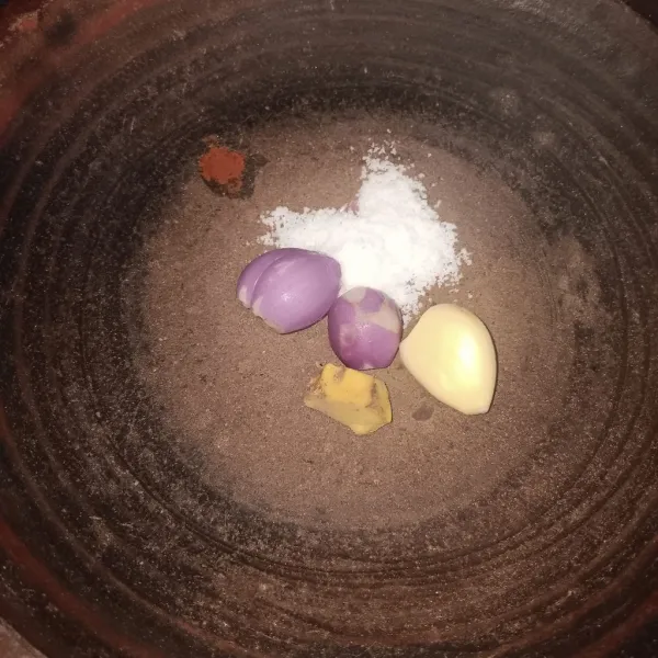 Haluskan bawang putih, bawang merah, temu kunci, dan garam menggunakan ulekan.