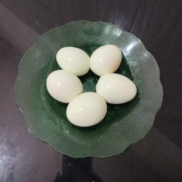 Rebus telur hingga matang, lalu kupas.