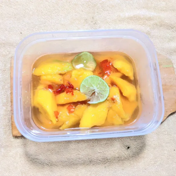Tambahkan air perasan jeruk nipis, lalu simpan asinan mangga ke dalam kulkas.