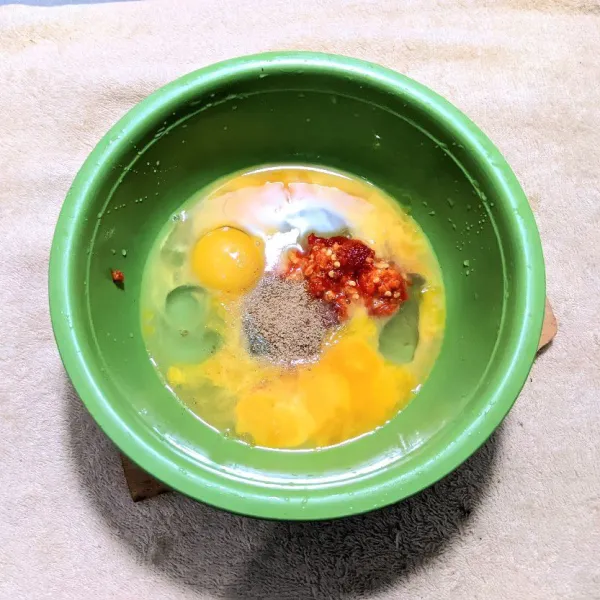 Tambahkan kunyit, bawang putih, cabe merah besar, dan cabe rawit sebagai bumbu halus, lalu tambahkan kaldu bubuk. Aduk rata.