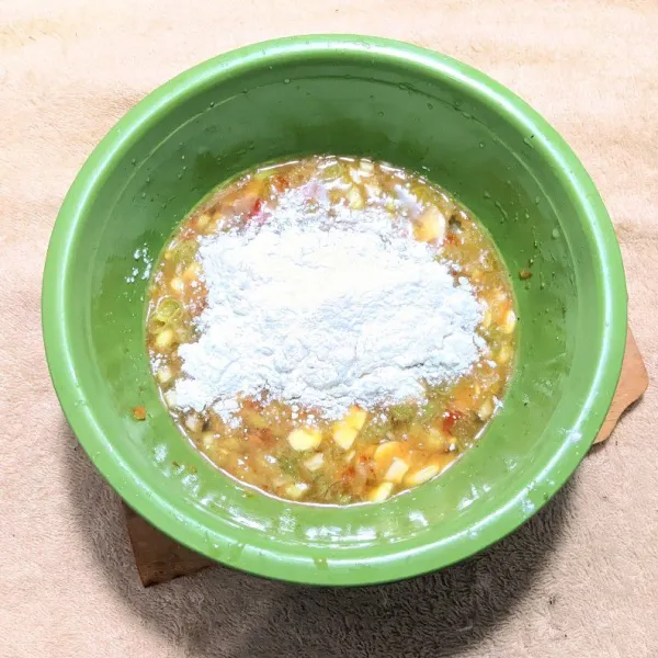 Tambahkan tepung terigu dan tepung beras, lalu aduk hingga adonan menyatu.