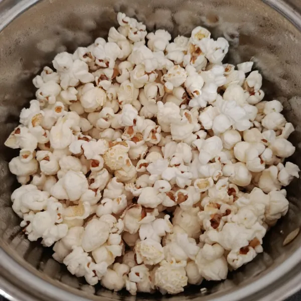 Tutup panci, lalu tunggu hingga ada suara ledakan. Sesekali goyangkan agar tidak gosong. Jika sudah tidak berbunyi atau meledak, matikan kompor.