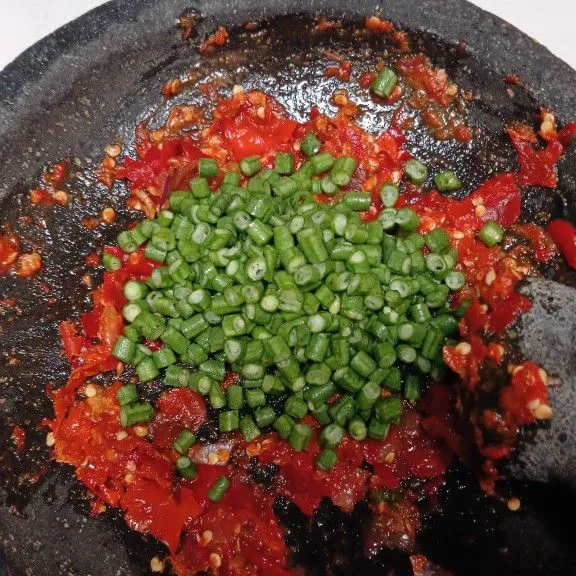 Setelah halus, masukkan kacang panjang yang sudah di potong kecil kecil, sambil diulek tipis.