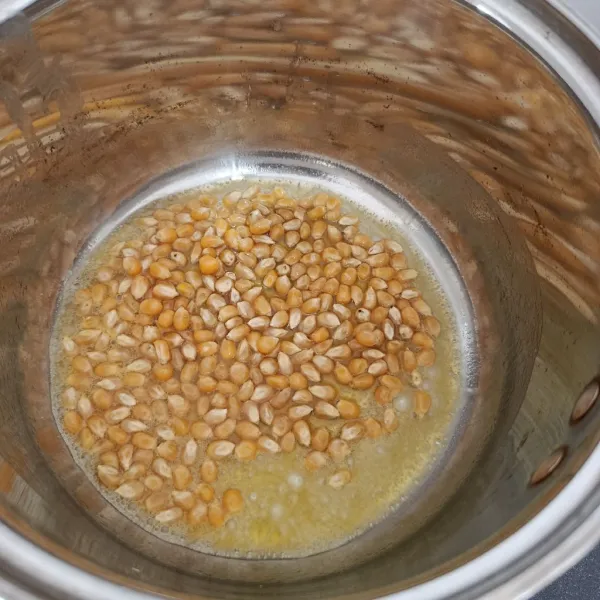 Masukkan jagung popcorn, lalu masak dengan api kecil.