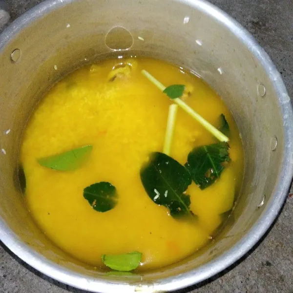 Kemudian ulek kunyit, tambahkan air, lalu saring dan masukkan ke dalam panci yang berisi beras, tambahkan jahe, daun jeruk, sereh, dan daun salam.