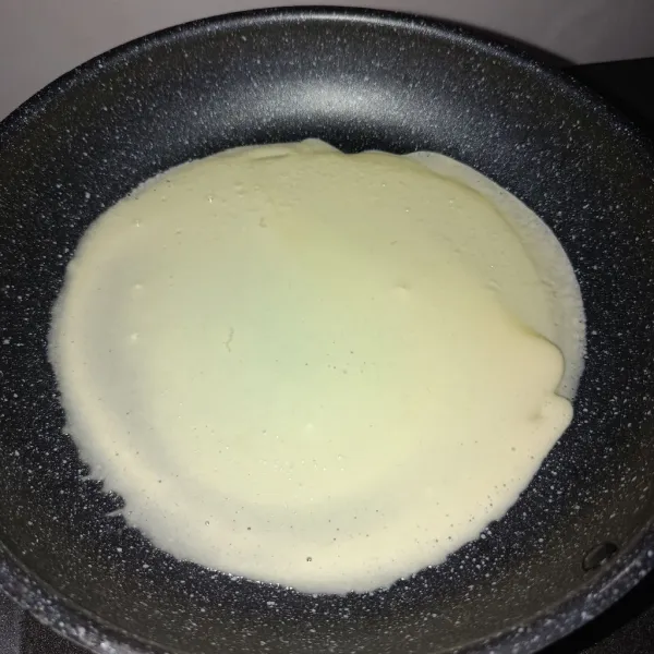 Panaskan pan, lalu tuangkan adonan dan ratakan ke seluruh permukaan pan.