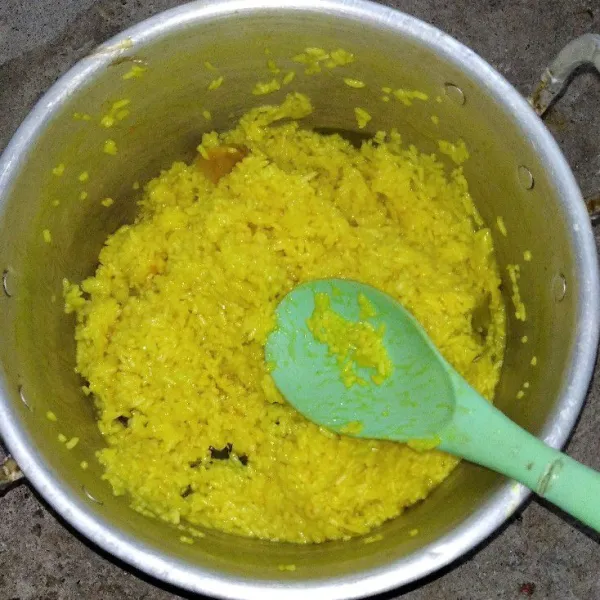 Masak beras dengan api sedang hingga air menyusut, lalu aduk agar merata