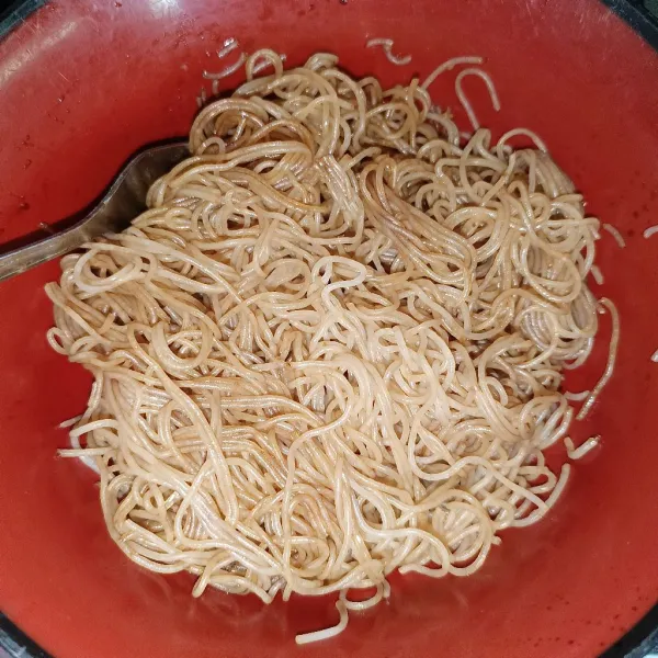 Rebus bihun sampai matang, lalu angkat dan tiriskan. Campurkan bihun dan kecap manis. Aduk rata.